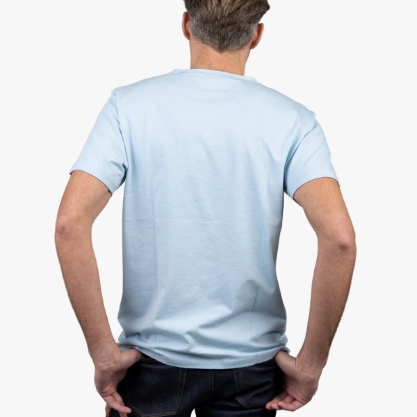Light Blue T-Shirt on Model Facing Backwards with Hands in Backpockets