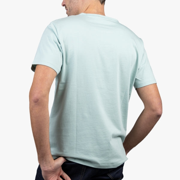 Light Green T-Shirt on Model Facing Backward at an Angle with Hand in Pocket