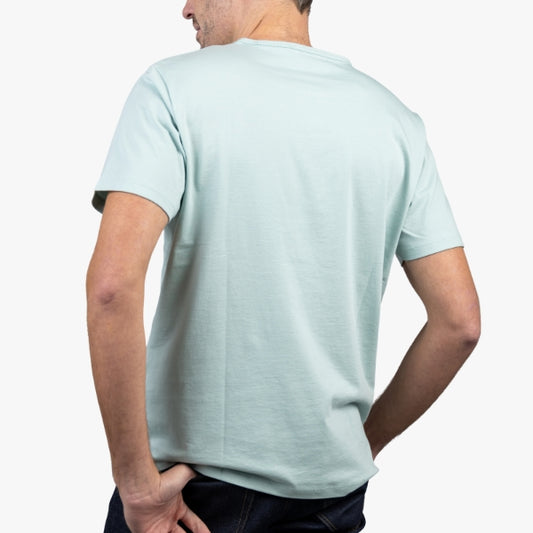 Light Green T-Shirt on Model Facing Backward at an Angle with Hand in Pocket